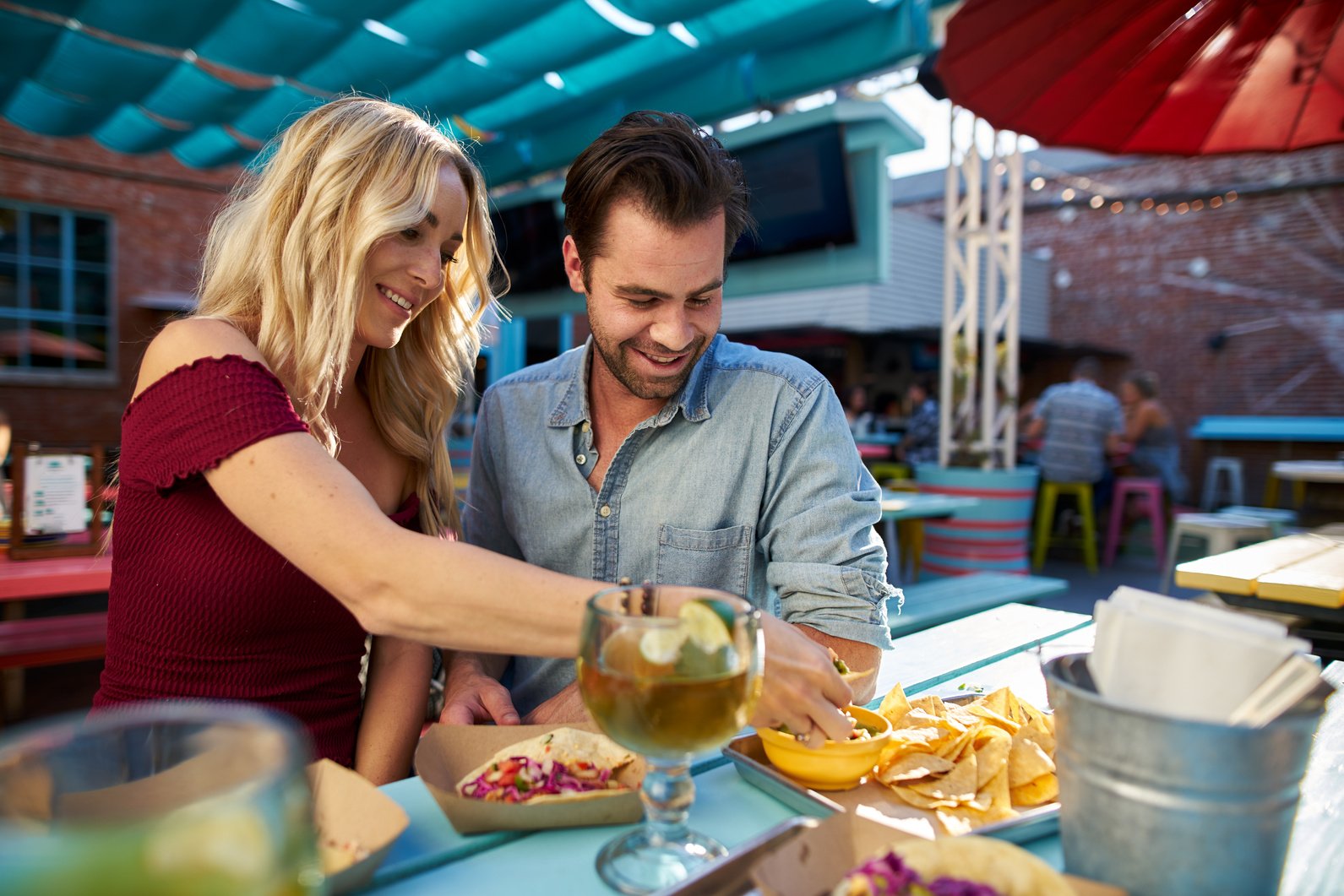 Romantic Couple Eating Tacos and Nachos at Mexican Restaurant